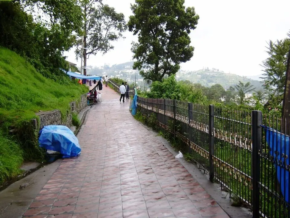 Visitors strolling the paved 1 km Coaker's Walk path at sunset, Kodaikanal town