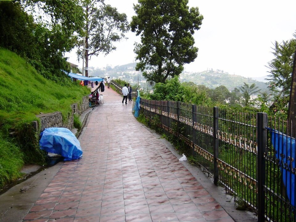 Visitors strolling the paved 1 km Coaker's Walk path at sunset, Kodaikanal town